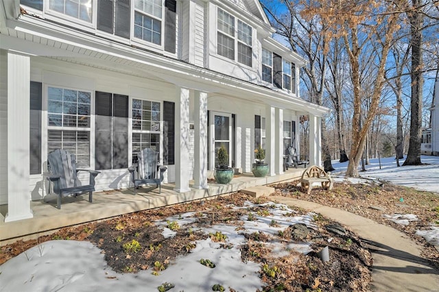 snow covered property entrance featuring a porch