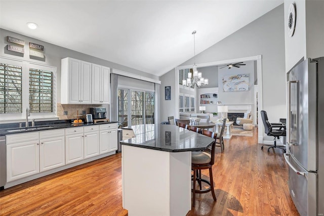 kitchen featuring appliances with stainless steel finishes, a breakfast bar, sink, and white cabinets