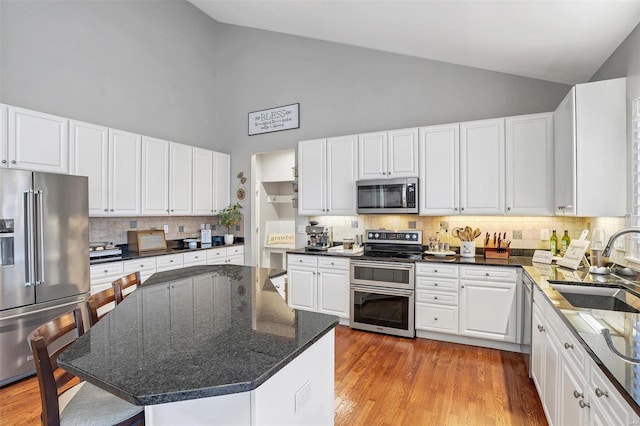 kitchen featuring sink, white cabinetry, light wood-type flooring, appliances with stainless steel finishes, and a kitchen island