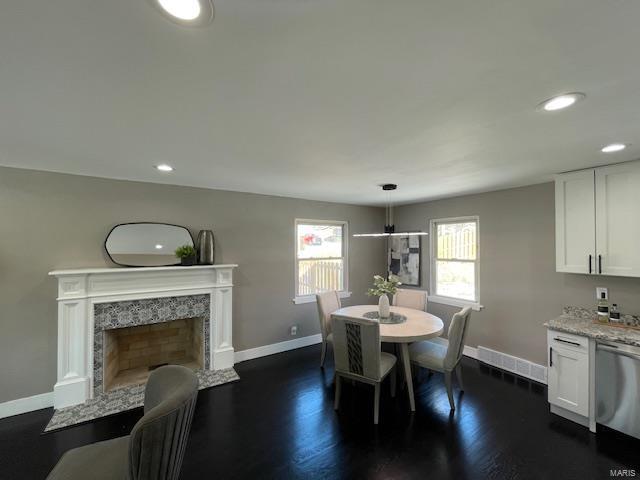 dining area with a premium fireplace and dark hardwood / wood-style flooring