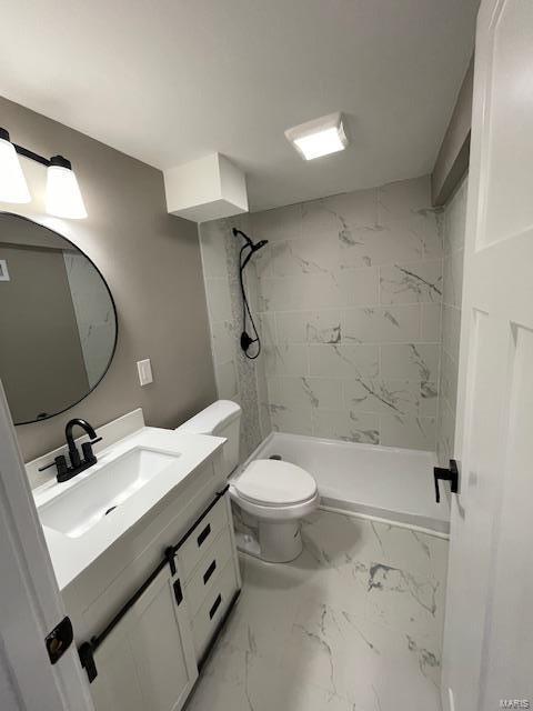 bathroom with vanity, toilet, and a tile shower