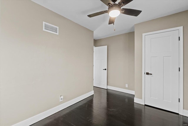 unfurnished room featuring dark wood-type flooring and ceiling fan