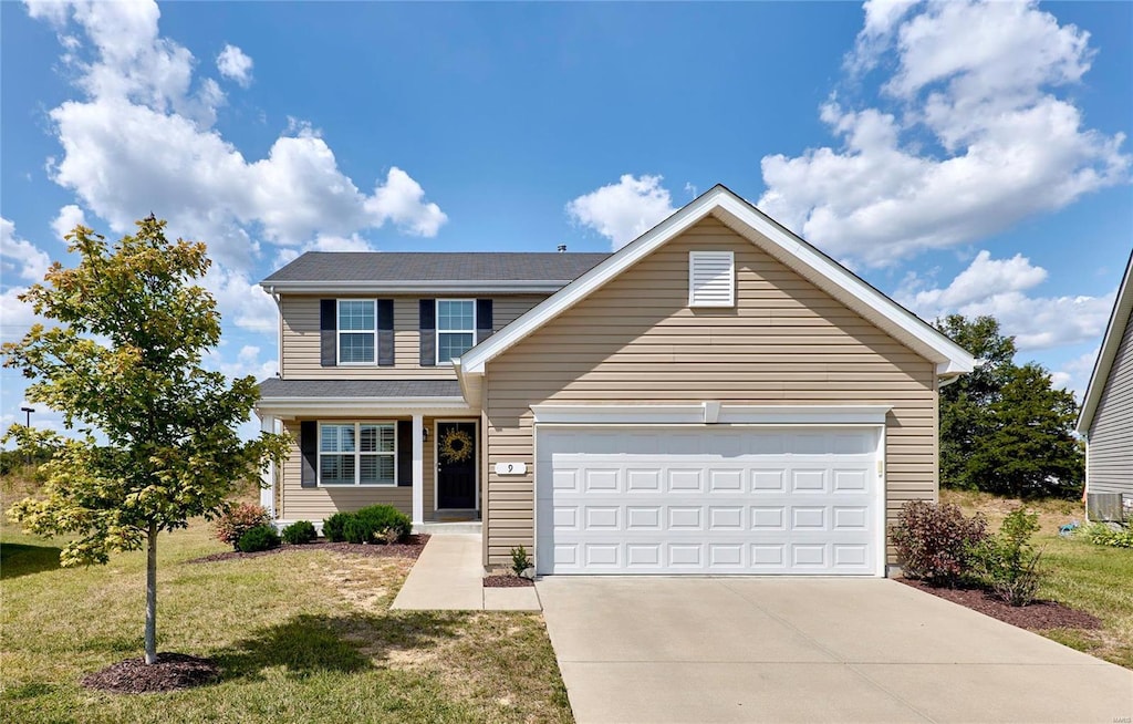 view of front of property with a garage and a front lawn