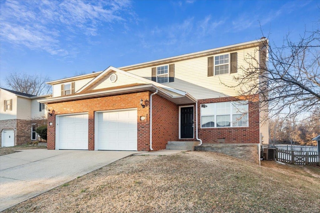 view of front property with a garage and central AC unit