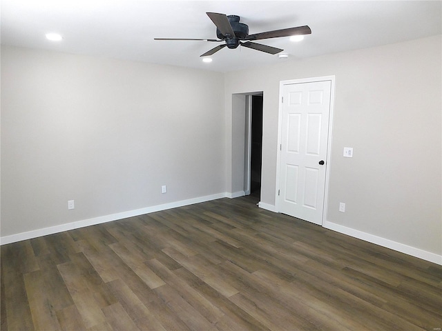 unfurnished room featuring ceiling fan, dark wood-style flooring, and baseboards