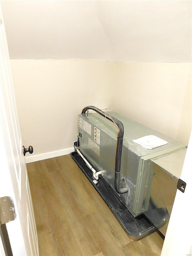 laundry area with laundry area, wood finished floors, and baseboards