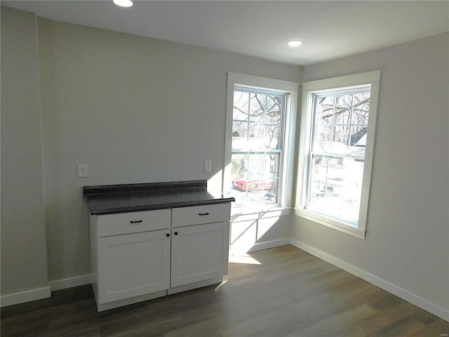 unfurnished dining area with recessed lighting, baseboards, and wood finished floors