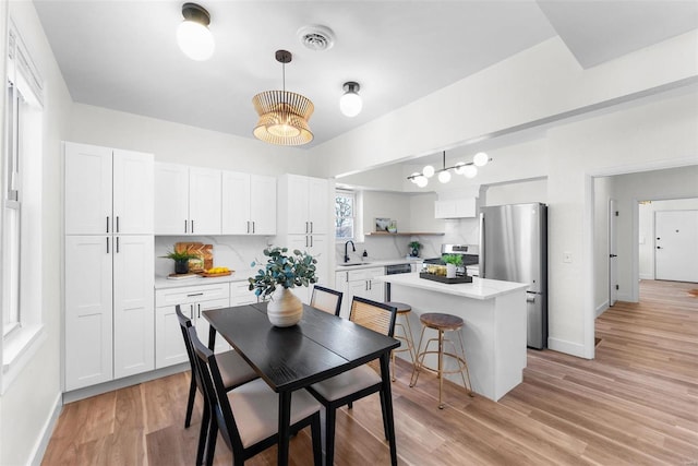 dining area featuring plenty of natural light, sink, and light wood-type flooring