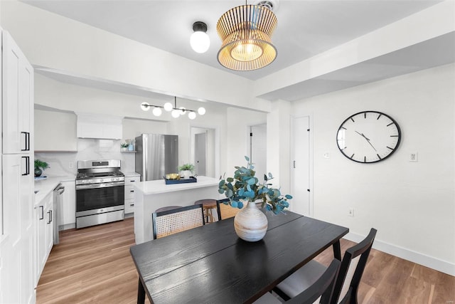 dining space with a chandelier and light hardwood / wood-style flooring