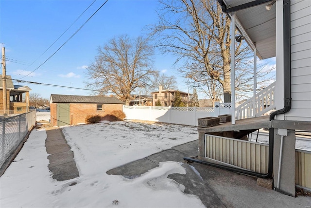 yard layered in snow featuring a storage shed