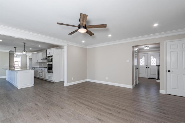 unfurnished living room featuring crown molding and dark hardwood / wood-style floors