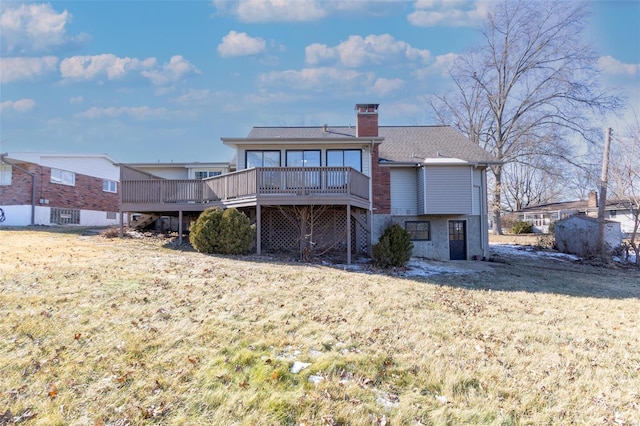 rear view of property with a yard and a deck