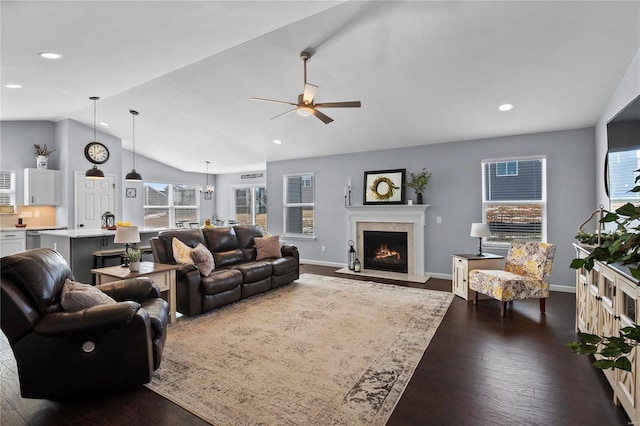 living room featuring vaulted ceiling, dark hardwood / wood-style floors, and ceiling fan