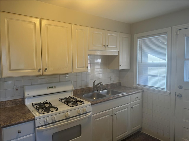 kitchen featuring sink, backsplash, gas range gas stove, and white cabinets