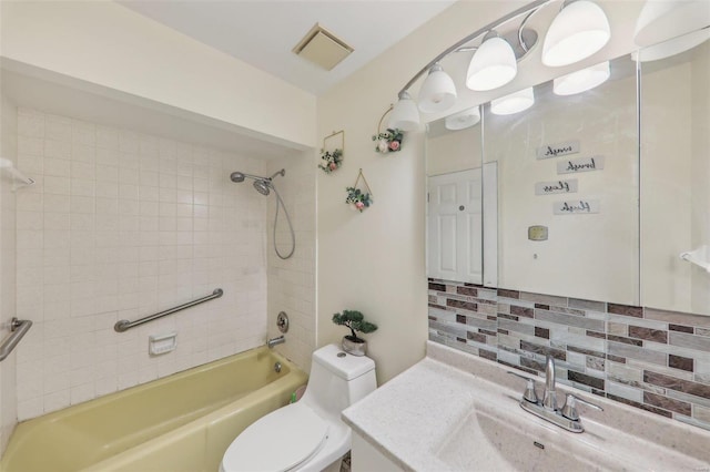 full bathroom featuring tiled shower / bath, vanity, toilet, and decorative backsplash