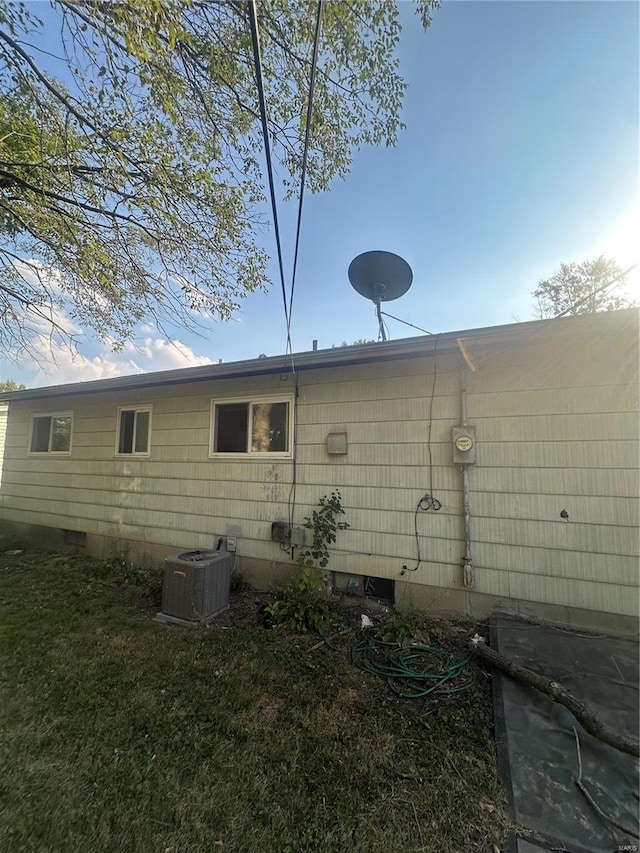 view of home's exterior featuring a lawn and central AC