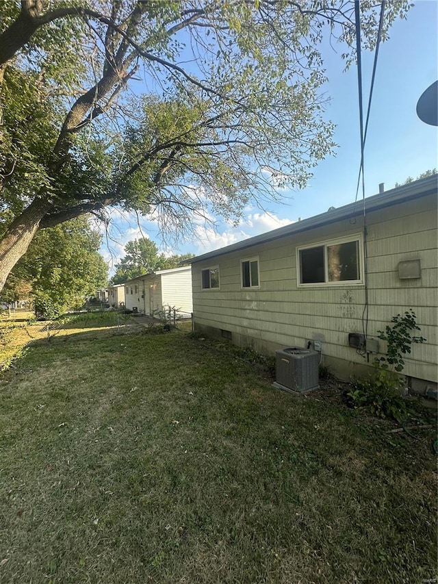 view of home's exterior with a yard and central AC