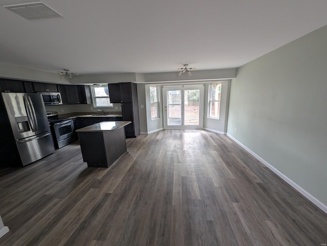 kitchen featuring sink, stainless steel appliances, a center island, and dark hardwood / wood-style flooring