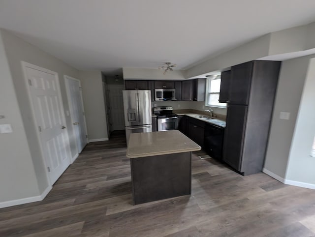 kitchen featuring sink, hardwood / wood-style flooring, a center island, and appliances with stainless steel finishes