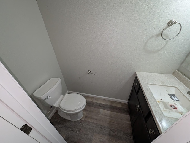 bathroom with wood-type flooring, toilet, and vanity