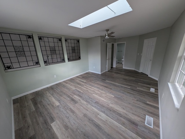 unfurnished room with wood-type flooring, ceiling fan, and a skylight