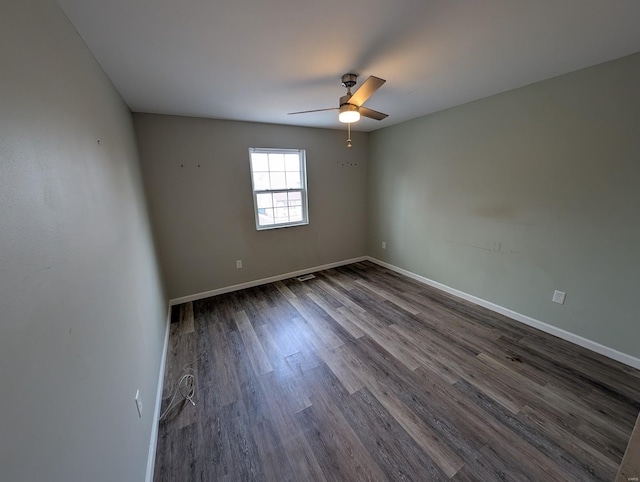 empty room with ceiling fan and dark wood-type flooring