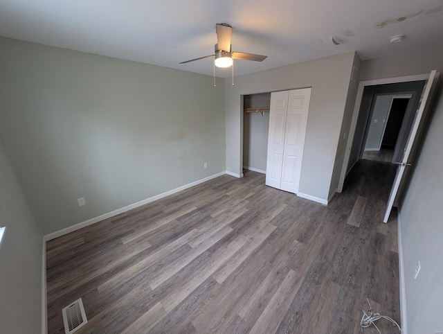 unfurnished bedroom featuring ceiling fan, wood-type flooring, and a closet