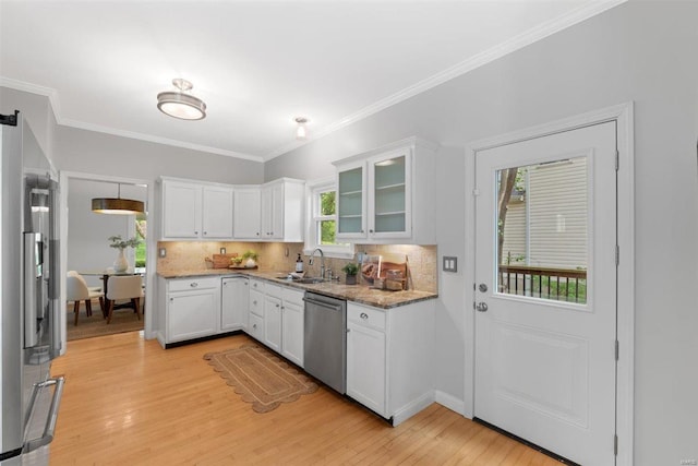 kitchen with white cabinets, appliances with stainless steel finishes, decorative backsplash, and a sink