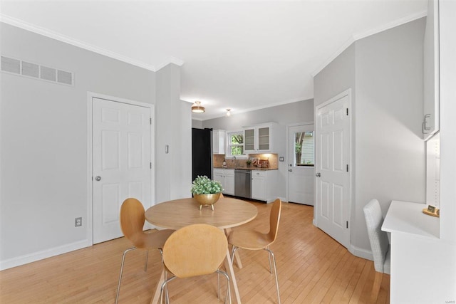 dining area featuring crown molding, baseboards, visible vents, and light wood-style flooring