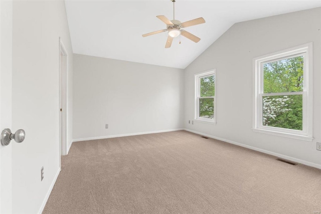 unfurnished room with baseboards, ceiling fan, lofted ceiling, and light carpet
