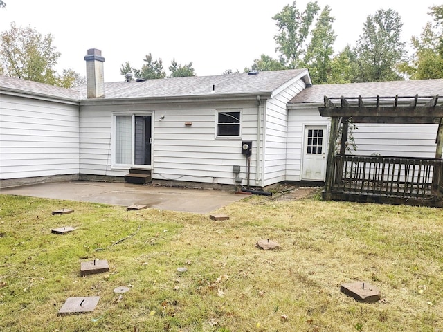 rear view of property featuring a lawn, a pergola, and a patio