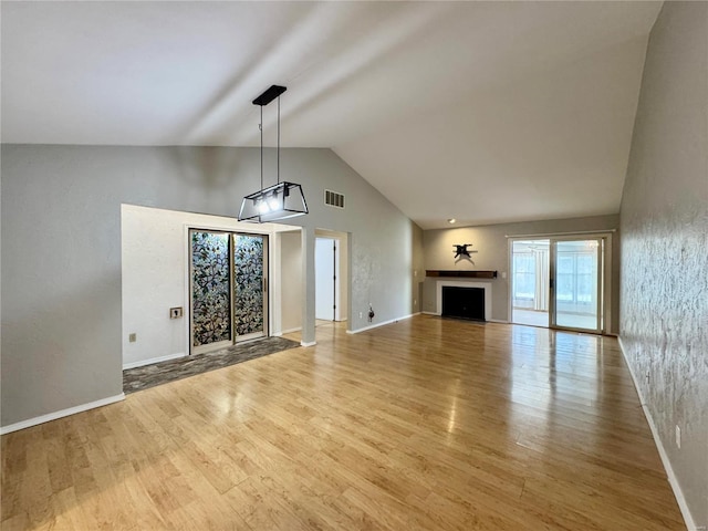 unfurnished living room with high vaulted ceiling and light hardwood / wood-style flooring