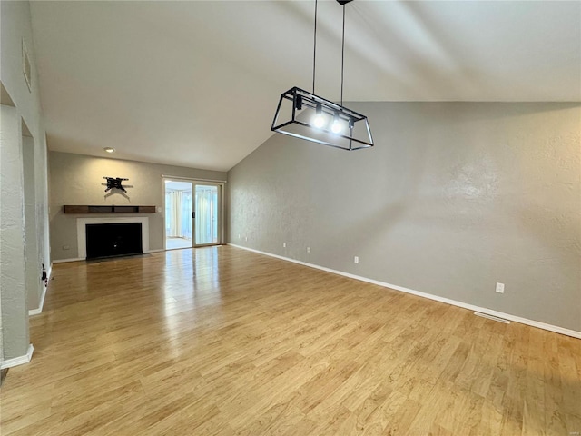 unfurnished living room with vaulted ceiling and light hardwood / wood-style floors