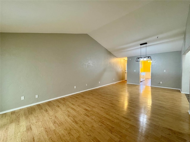 unfurnished living room featuring lofted ceiling and hardwood / wood-style floors