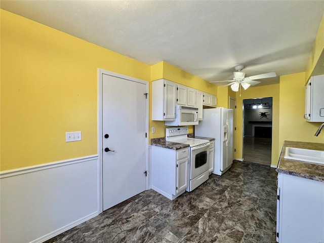 kitchen featuring white cabinetry, sink, and white appliances