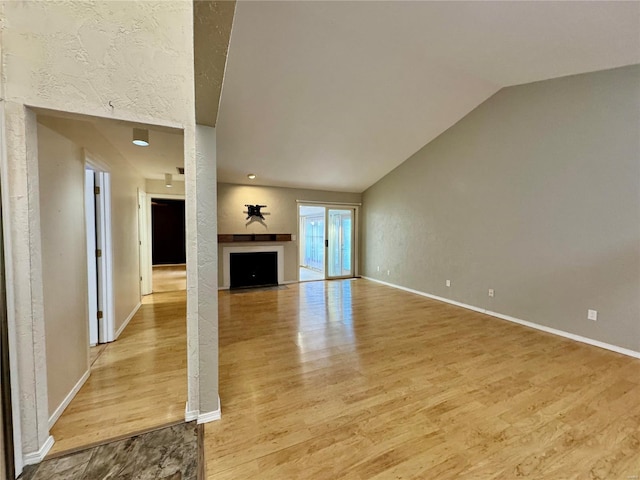 unfurnished living room featuring lofted ceiling and light hardwood / wood-style floors