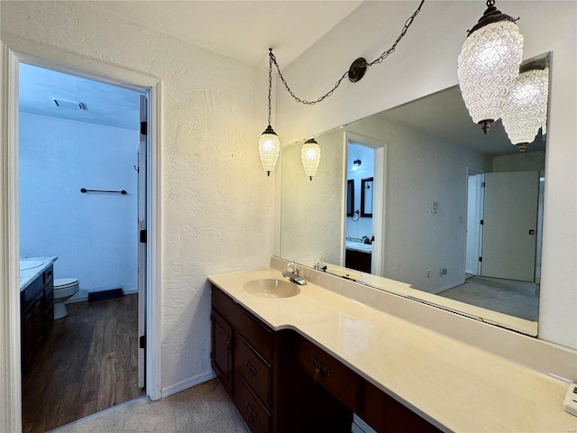 bathroom with hardwood / wood-style flooring, vanity, and toilet