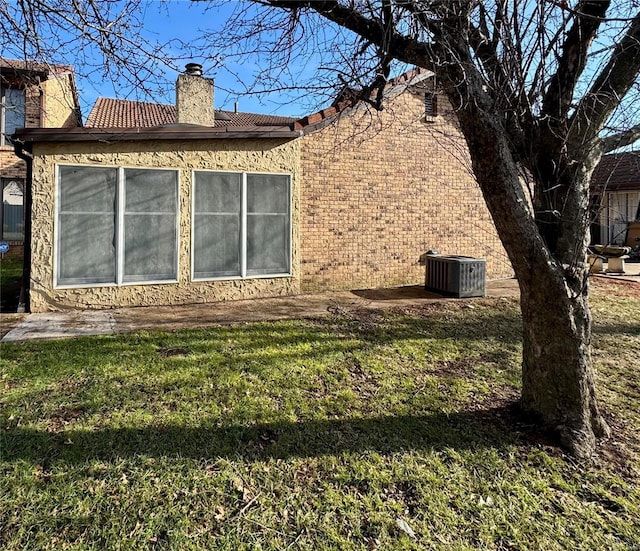 view of side of home featuring a lawn and central air condition unit