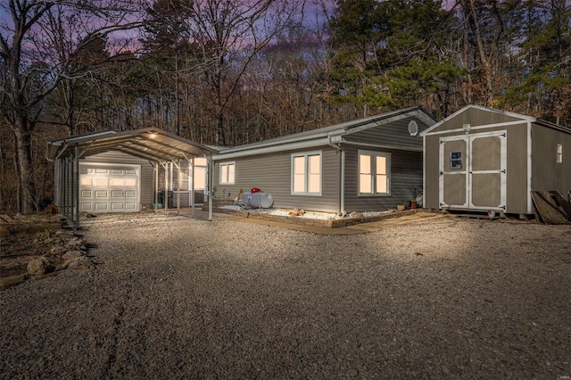 view of front of home with a carport and a storage unit