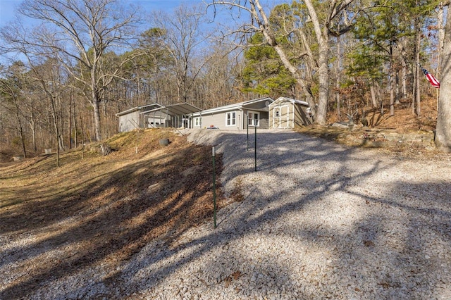 ranch-style house featuring a carport and a storage shed