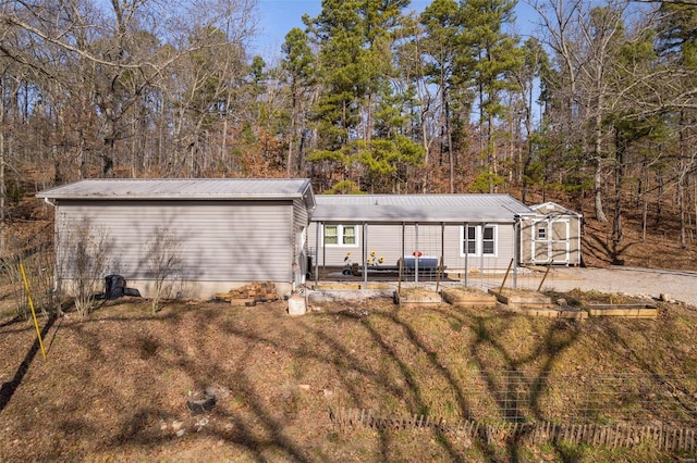 view of front of house with a front yard and a storage shed