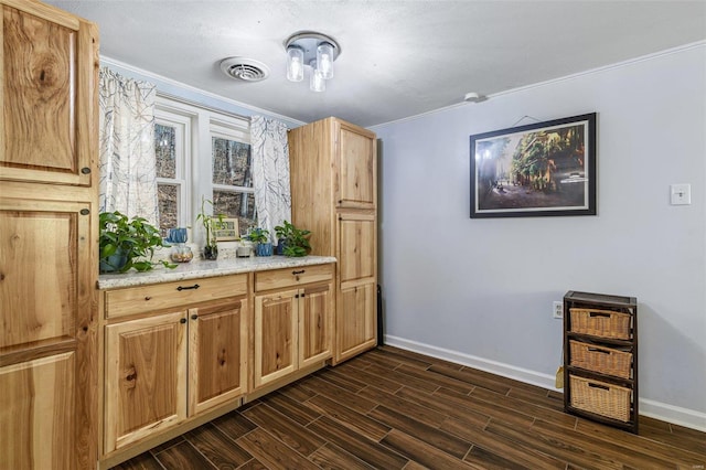 bar with light stone counters and ornamental molding