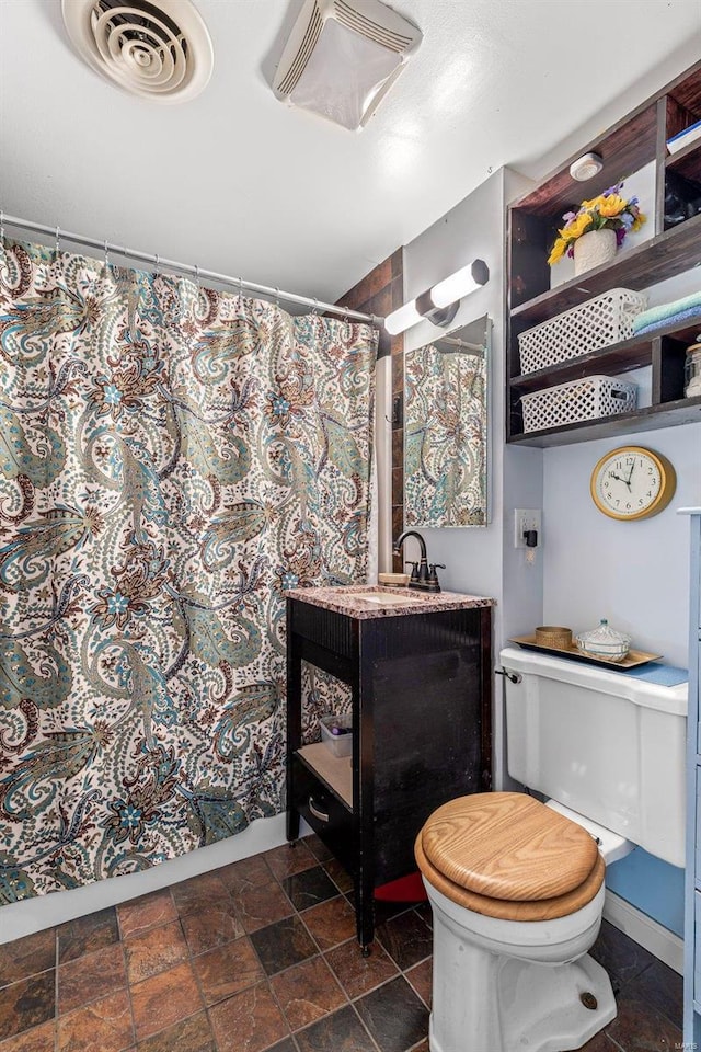 bathroom with vanity, walk in shower, and toilet