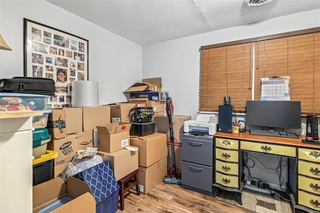 home office featuring a textured ceiling and light hardwood / wood-style flooring