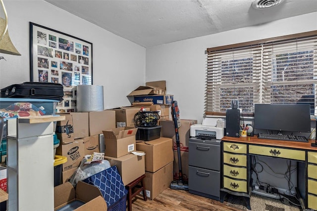 office area with hardwood / wood-style floors and a textured ceiling