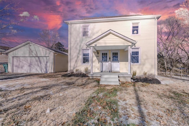 view of property featuring a garage, an outbuilding, and covered porch