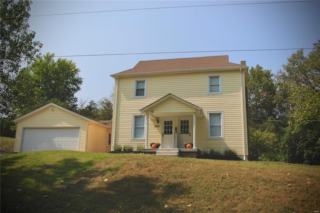 view of front facade with an outbuilding, a garage, and a front yard