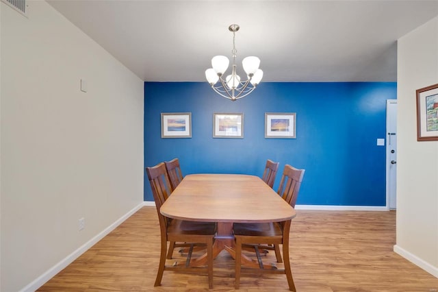 dining room with a chandelier and light hardwood / wood-style floors