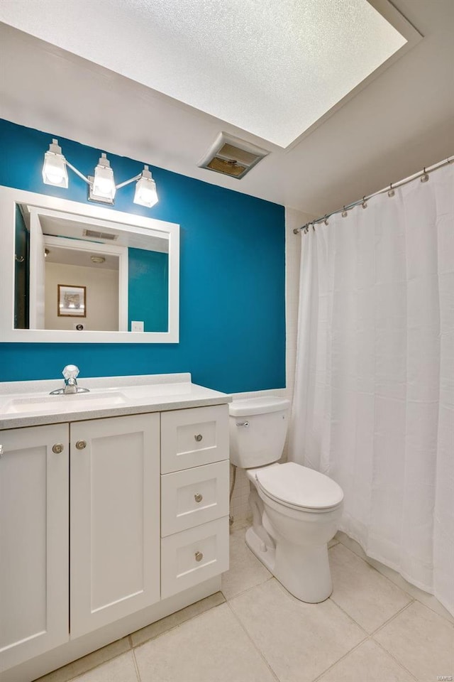 bathroom featuring tile patterned floors, toilet, vanity, and a textured ceiling