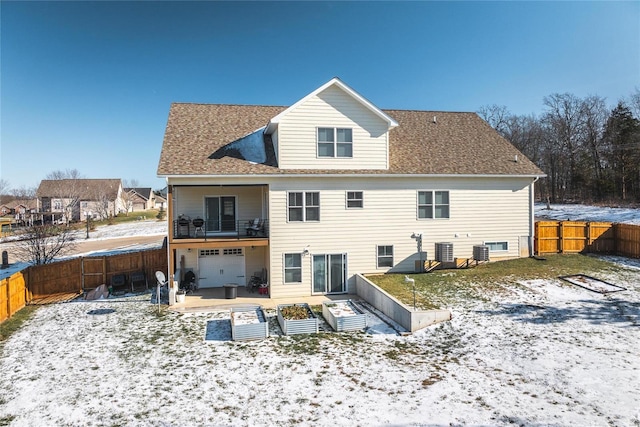 snow covered rear of property featuring central air condition unit